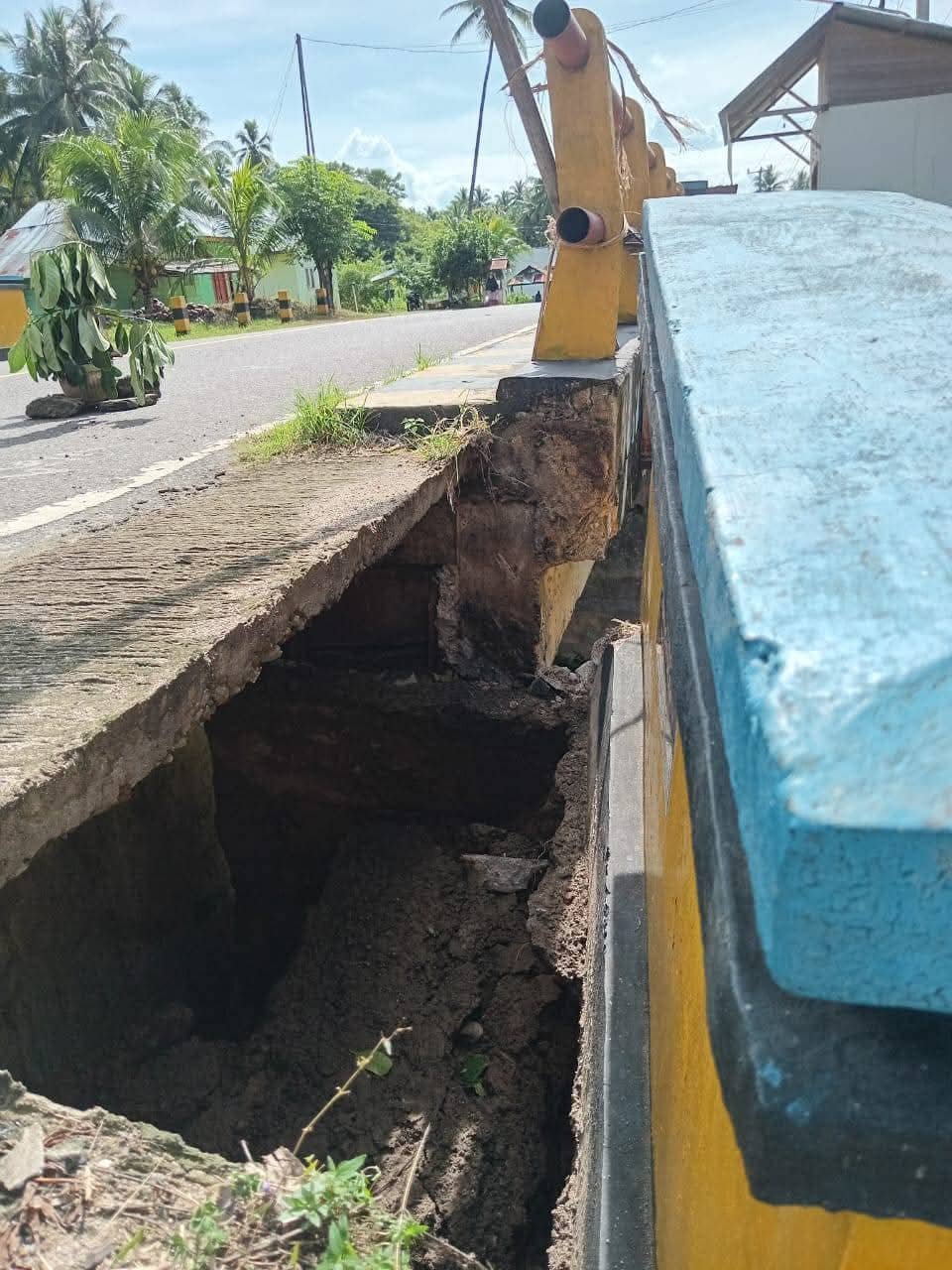 Sisi trotoar jembatan yang terletak di Desa Hutamonu yang terlihat ambles dan membentuk lubang besar