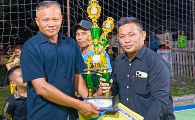 PLT Camat Botumoito, Halim Iyabu, saat menyerahkan hadiah pada agenda Karang Taruna Cup Tournament Volly Ball dan Sepak Takraw yang digelar oleh Karang Taruna Desa Bolihutuo, Sabtu 20 Desember 2025.